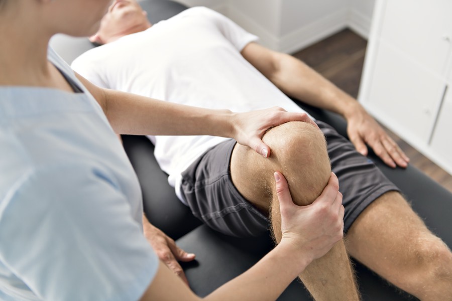 Physiotherapist assessing a knee